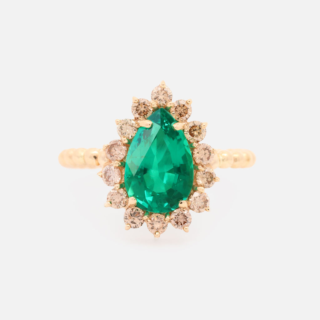 Anillo Magnum Oro Amarillo 14K con Esmeralda Laboratorio y Diamantes Champagne.