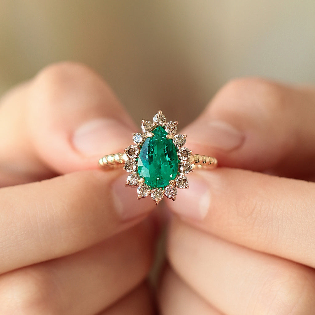 Anillo Magnum Oro Amarillo 14K con Esmeralda Laboratorio y Diamantes Champagne.